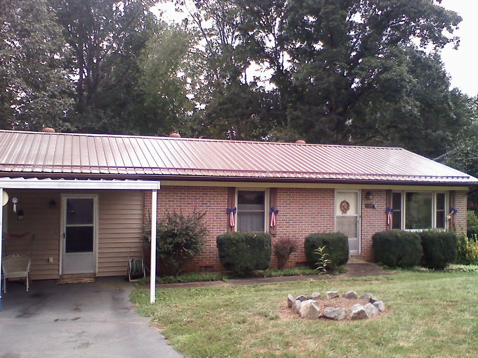 Bronze metal roof and carport on a brick ranch home — Roof Repair work by our crew in Houston